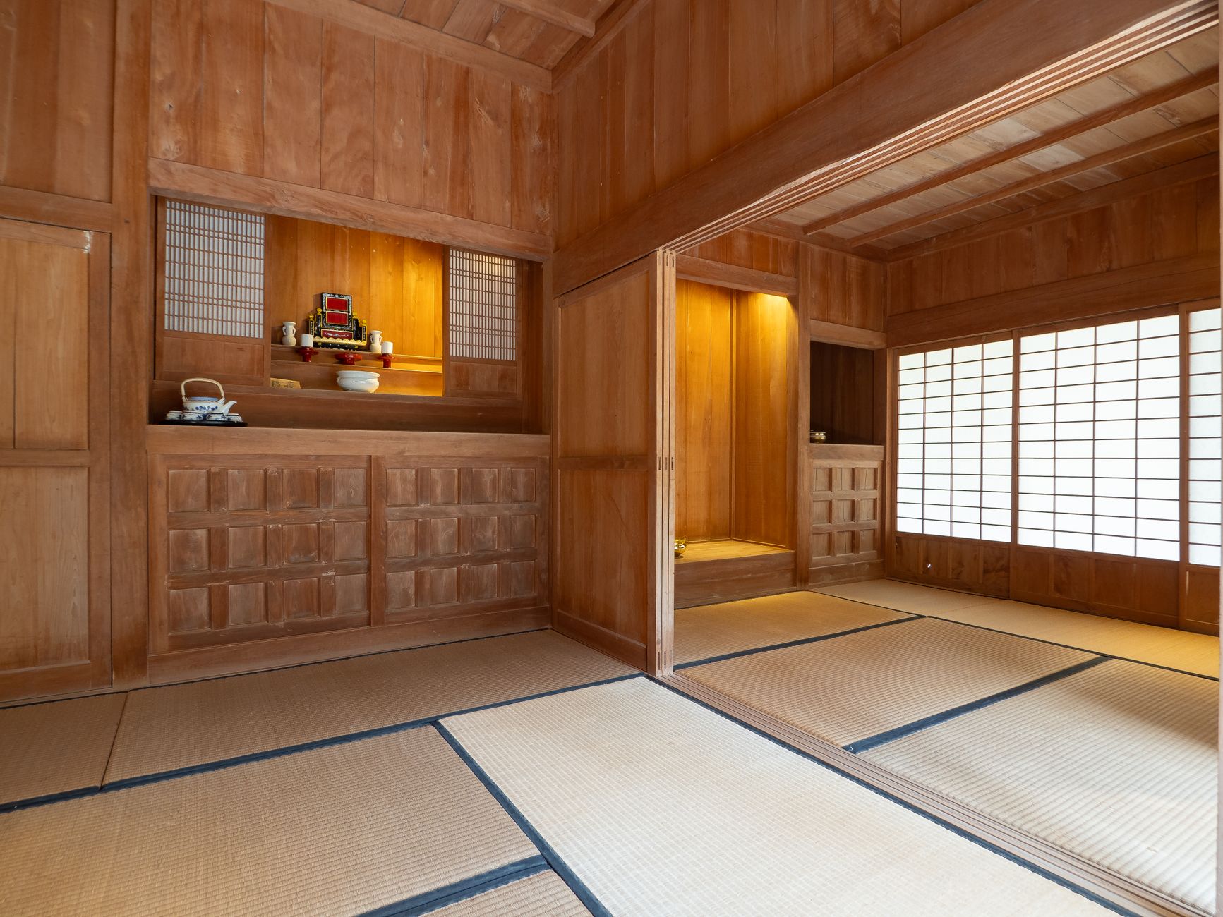 Traditional Japanese tea room with paper shoji screens overlooking maple trees